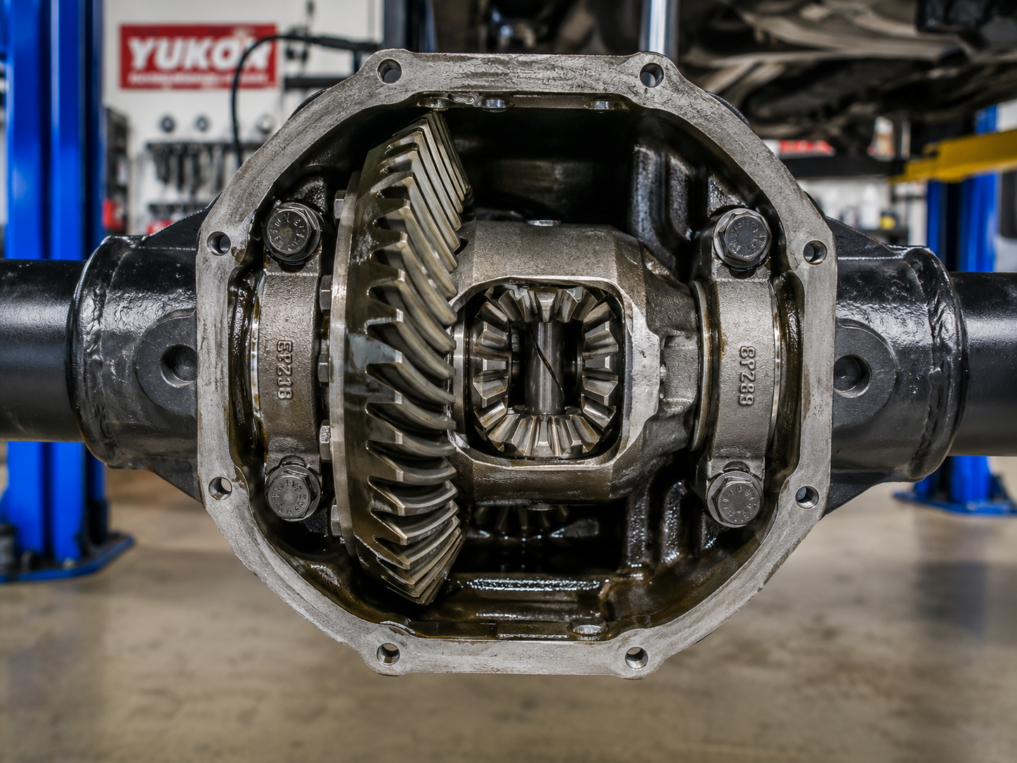 Differential housing and ring-and-pinion gears laid out on the bench during a re-gear